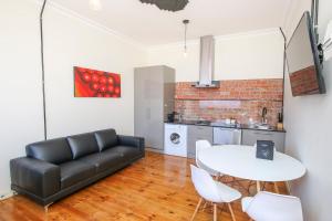 a living room with a black couch and a white table at Indulge Apartments - The Urban Collection in Mildura