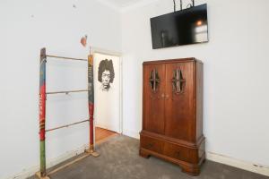 a room with a cabinet and a television on a wall at Indulge Apartments - The Urban Collection in Mildura
