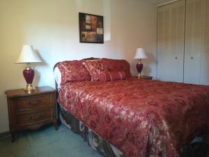 a bedroom with a red bed and two lamps at Rosedale Manor in Duncan