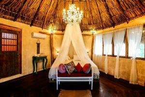 a bedroom with a bed with a chandelier at XscapeTulum in Tulum