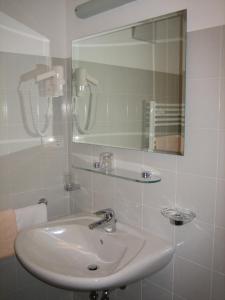 a white bathroom with a sink and a mirror at Garni - Appartement Neumairhof in Rasun di Sopra