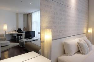 une chambre d'hôtel avec un lit et une télévision dans l'établissement Kemang Icon, à Jakarta
