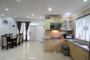 a kitchen with a table and a dining room at Diyar Villas Puncak M3/8 in Puncak