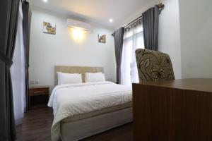 1 dormitorio con cama, silla y escritorio en Diyar Villas Puncak M3/8, en Puncak