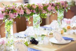 a table with vases filled with pink flowers on it at Hotel Karuizawa Elegance in Karuizawa