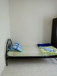 a small bed in a corner of a room at Saujana Homestay in Ranau