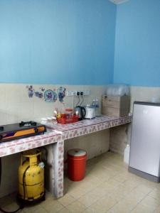 a kitchen with a table with a counter top at Saujana Homestay in Ranau
