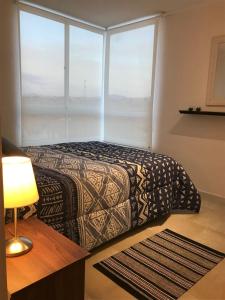 a bedroom with a bed and a large window at Departamento La Herradura in Coquimbo