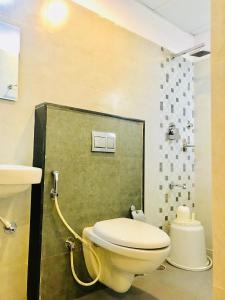 a bathroom with a toilet and a sink and a shower at REGALIA INN &SUITES in Mysore