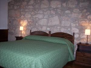 una camera da letto con un letto con un piumone verde e due lampade di Case di Cutalia - Villa Cutalia a Camemi