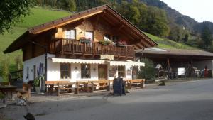 a building with a balcony and benches in front of it at Gruberhof in Lagundo