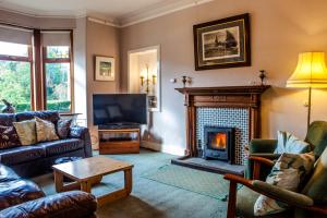 sala de estar con TV y chimenea en Shelburne Lodge, en Cairnbaan