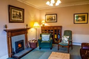 sala de estar con chimenea y 2 sillas en Shelburne Lodge, en Cairnbaan