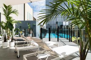 a balcony with lounge chairs and a swimming pool at Adelphi Hotel in Melbourne