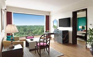 أوبروي نيودلهي في نيودلهي: غرفة معيشة مع نافذة كبيرة وغرفة مع أريكة