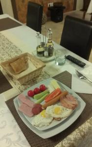 a plate of food with eggs and vegetables on a table at Pensiunea Cristina in Craiova