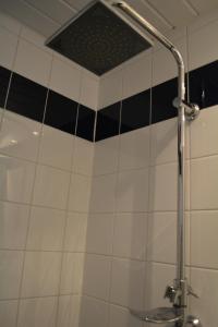 a shower in a bathroom with black and white tiles at Suite 17 in Eindhoven