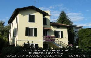デセンツァーノ・デル・ガルダにあるAppartamento Villa Margheritaの白い家(バルコニー付)
