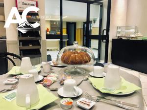 a table with a cake in a glass dish on it at Al Centro in Verbania