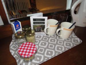 un tavolo con due barattoli in muratura e due tazze di caffè di Wiltshire Rondavel a Port Alfred
