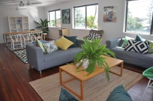 a living room with two couches and a table at Yeppoon Beachhouse in Yeppoon