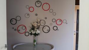 a vase of flowers on a table with circles on the wall at Casa delle Camelie in Sorico