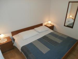 sypialnia z łóżkiem i 2 szafkami nocnymi z lampkami w obiekcie Apartments Nada w mieście Vodice