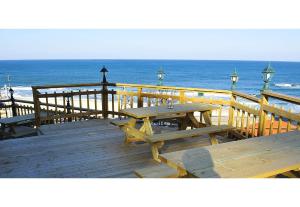 a wooden deck with a picnic table on the beach at Pension Badawa in Gangneung