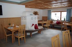 ein Esszimmer mit einem Tisch, Stühlen und einem Herd in der Unterkunft Wohlfühlpension Tirolerhof in Partenen