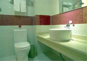 a bathroom with a sink and a toilet and a mirror at Thank Inn Chain Hotel Yunnan Lijiang Old Town South Gate in Lijiang