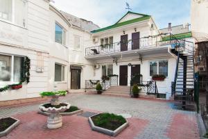 a large white building with a fountain in the courtyard at Apart Hotel Rishelye in Odesa