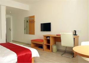 um quarto com uma cama, uma secretária e uma televisão em Thank Inn Chain Hotel Yunnan Lijiang Old Town South Gate em Lijiang