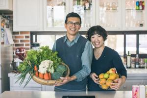 un homme et une femme détenant des paniers de fruits et légumes dans l'établissement Sunday Home, à Dayin