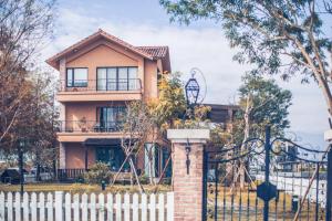 une maison avec une clôture devant elle dans l'établissement Sunday Home, à Dayin