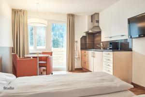 Habitación de hotel con cama y cocina en Serviced Apartments by Solaria, en Davos