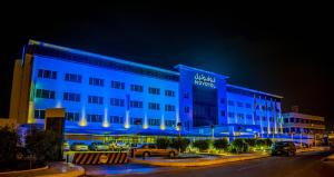 a hotel with a blue lit up building at night at Novotel Yanbu Albahr in Yanbu
