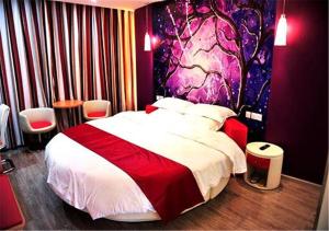 um quarto com uma cama grande e uma parede colorida em Thank Inn Chain Hotel Yunnan Lijiang Old Town South Gate em Lijiang
