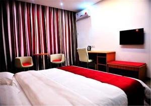 um quarto de hotel com uma cama, uma secretária e uma televisão em Thank Inn Chain Hotel Yunnan Lijiang Old Town South Gate em Lijiang