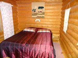 a room with a bed in a log cabin at Matila's Cottages in Sumiainen