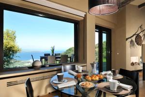 une salle à manger avec une table et une grande fenêtre dans l'établissement Villaflair - Design Villa Porto Ercole, à Monte Argentario