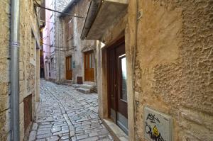 een steegje in een oud gebouw met een deur bij Nella Apartment in Rovinj