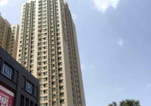 un edificio alto con un cartel delante en Jinjiang Inn Select XiAn High Speed Train Station Fengchengqi Road en Xi'an