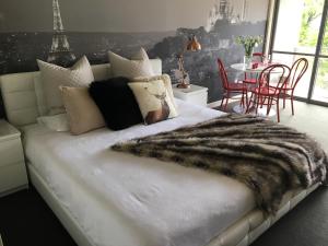 a bedroom with a bed with a fur blanket on it at Paris Lorne in Lorne