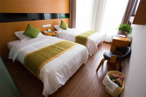 a hotel room with two beds and a chair at Vatica Suzhou Yongqiao District Yinhe 2 Road Wanda Plaza Hotel in Suzhou