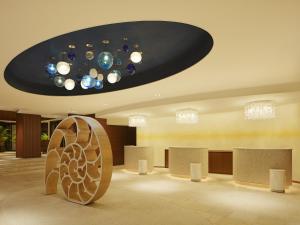 a lobby with a chandelier and a room with counters at Sheraton Okinawa Sunmarina Resort in Onna