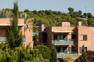 an apartment building with trees in the foreground at Pierre & Vacances Salou in Salou