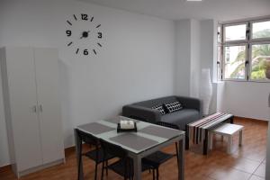 un soggiorno con divano e orologio sul muro di Apartamento Quintana a Arinaga