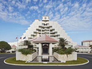 a large white building with a clock tower on it at Sheraton Okinawa Sunmarina Resort in Onna