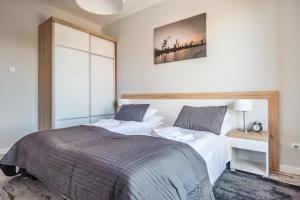 a bedroom with two beds and a mirror at Apartamenty Sun & Snow Stara Stocznia in Gdańsk