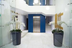 - un couloir avec deux grands vases fleuris dans l'établissement Aleph Boutique Hotel, à Byblos
